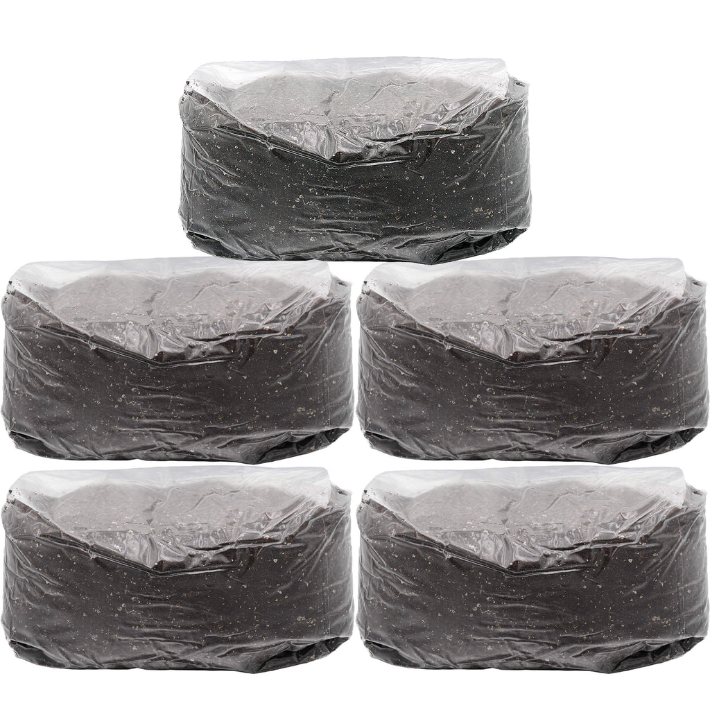 Five sealed rectangular blocks of manure-based mushroom substrate, each weighing five pounds. The blocks are tightly wrapped in clear plastic, showing a dark, finely textured organic material. Ideal for bulk mushroom cultivation.